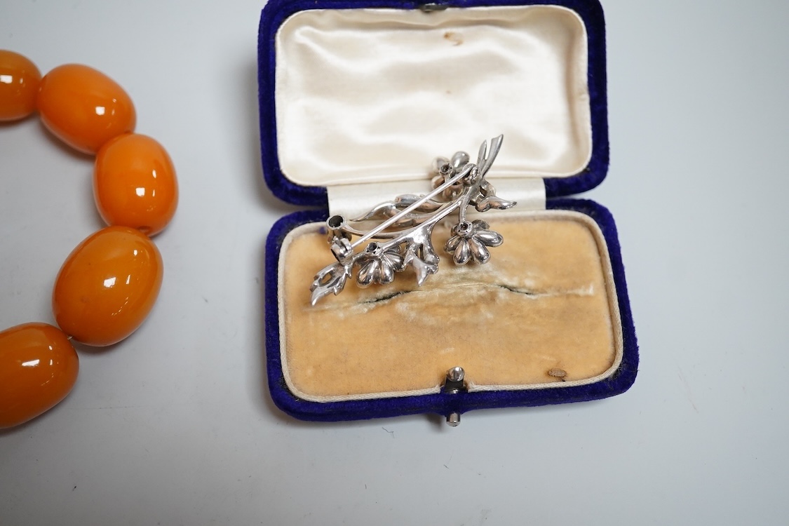 A group of antique and later jewellery inc. cased paste set spray brooch, a Mexican paste set brooch, a paste set shoe buckle and a pressed amber necklace.